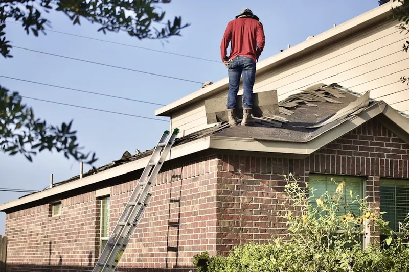 Professional roofer working on a residential roof in Bel-Aire Woods